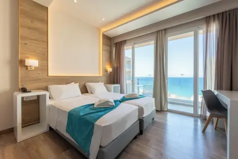 Nowoczesny pokój hotelowy z dwoma łóżkami i widokiem na morze.